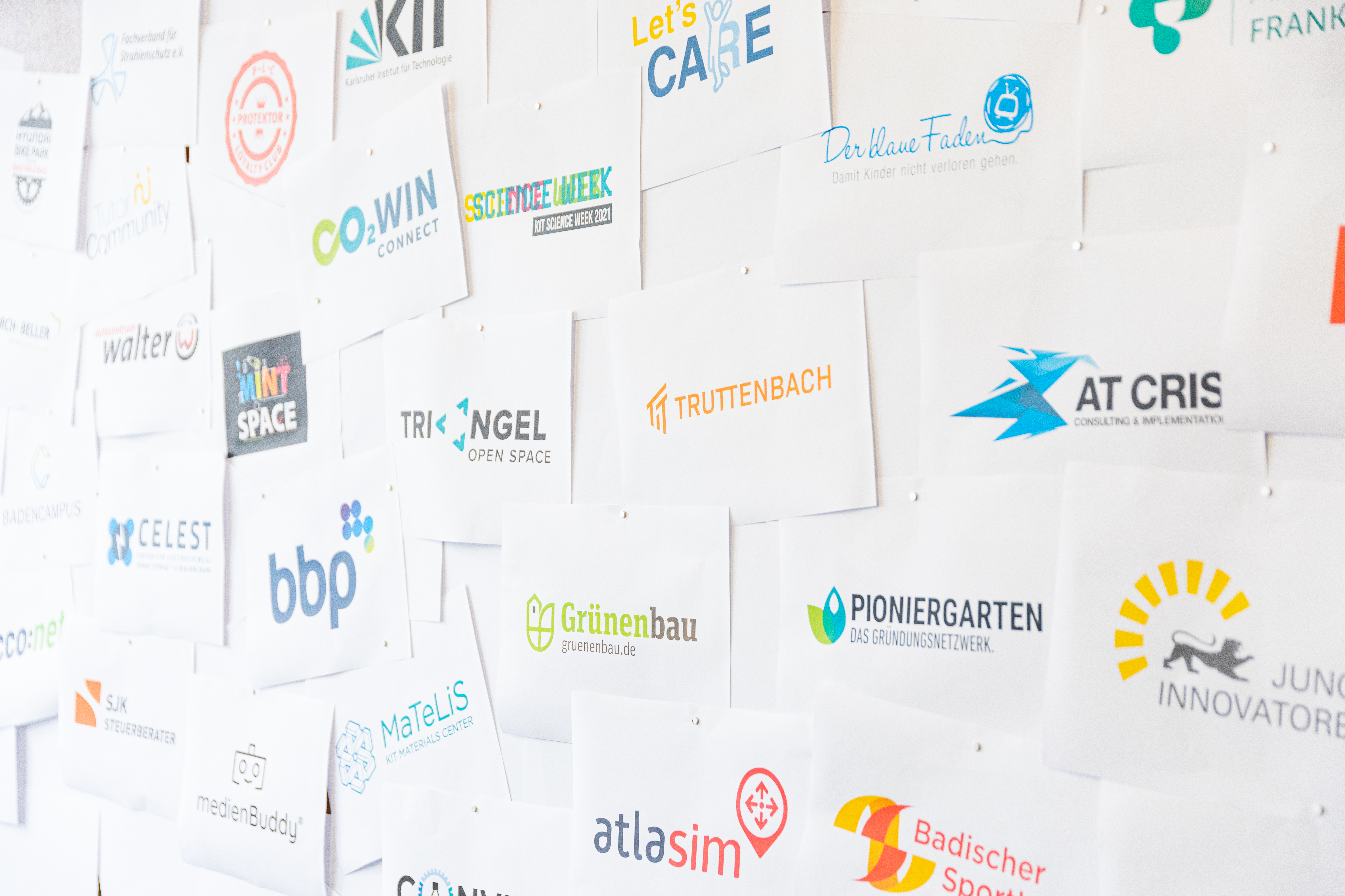 Eine Wand, die mit zahlreichen Logos geschmückt ist, die die Vielfalt und Einzigartigkeit der Marken repräsentiert.